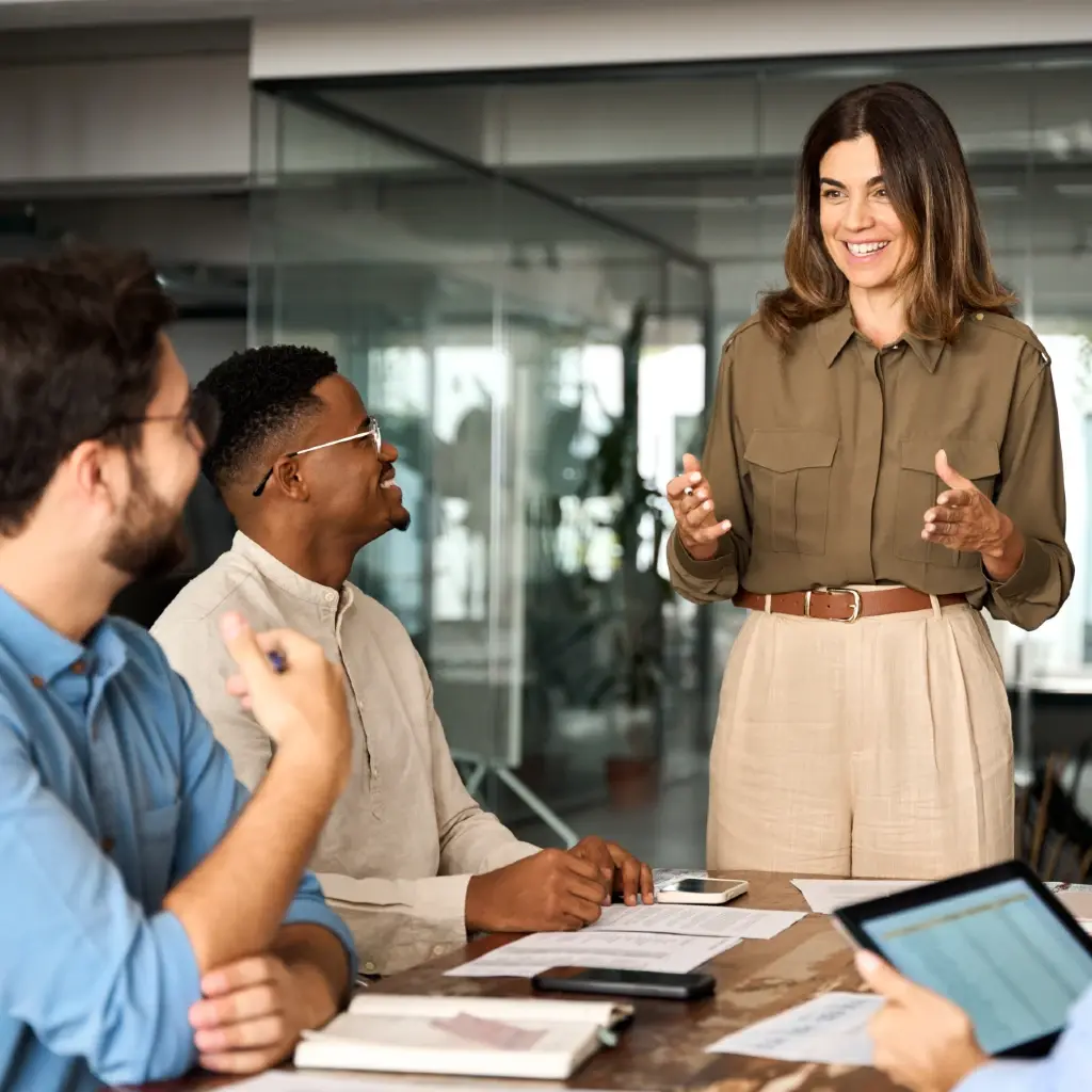 A woman discussing a project before her coworkers.