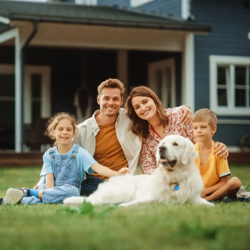 A family of 4 with their dog sitting on the front garden.