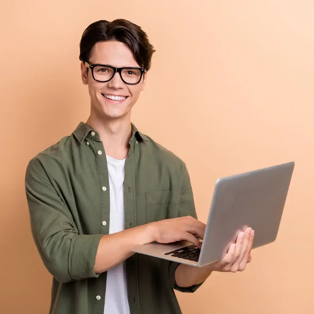 A man with glasses holding a laptop.